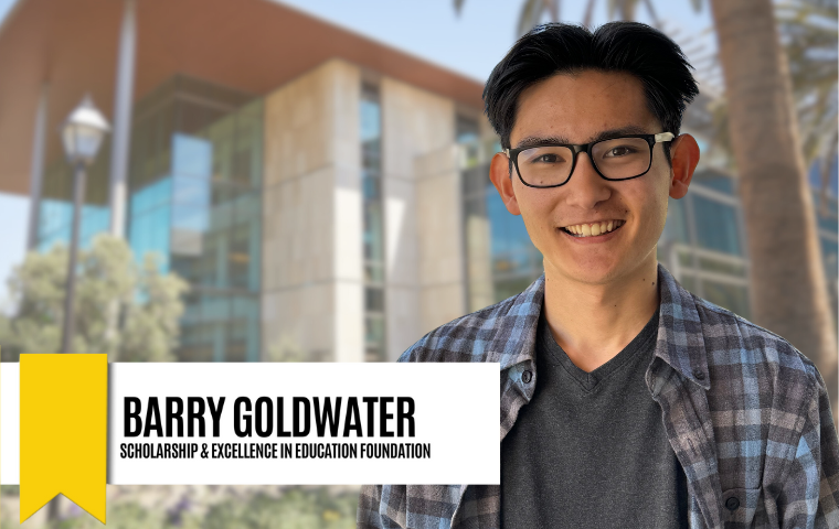 Young man with short black hair, a center part, and glasses wearing an unbuttoned flannel shirt with gray t shirt underneath, standing in front of SCDI building on Santa Clara's campus. Graphic reads "Barry Goldwater - Scholarship & Excellence in Education Foundation"