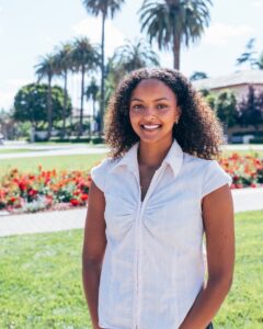 Saron Weldemariam in white shirt with Palm Drive in background, facing away from Mission Church.
