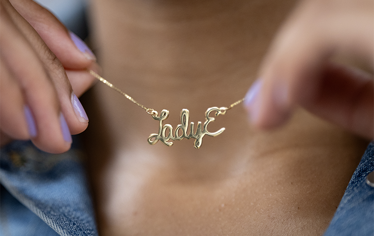 Close-up photo of Lady Elizabeth Roy 24 holding her Lady E necklace.