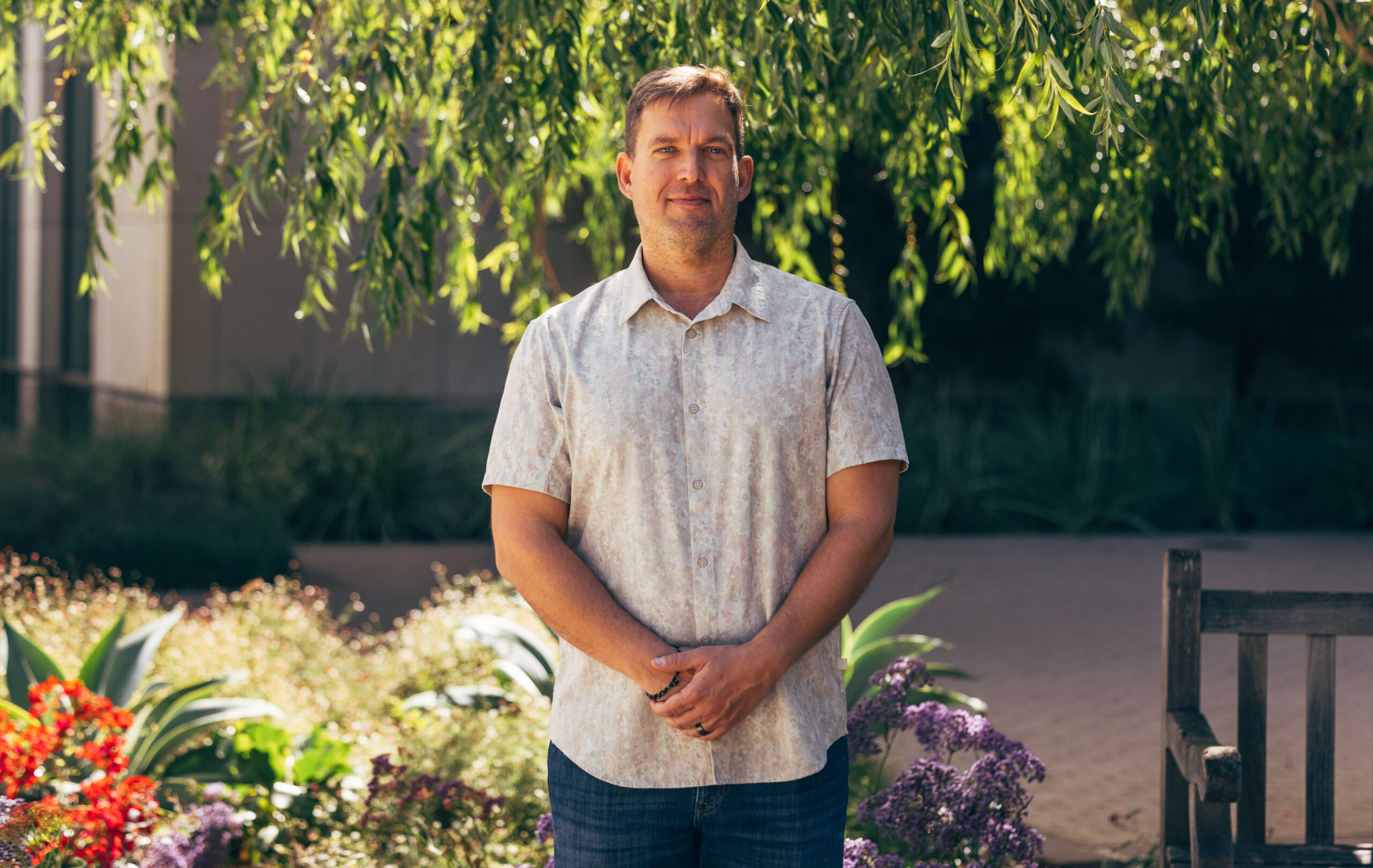 Man stands in front of tree.