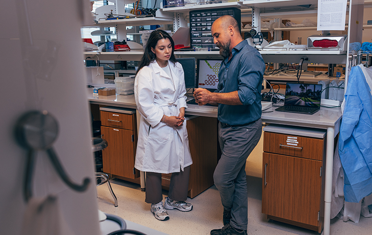 Rana Altay and Emre Araci (right) chat in their lab in SCDI at Santa Clara University