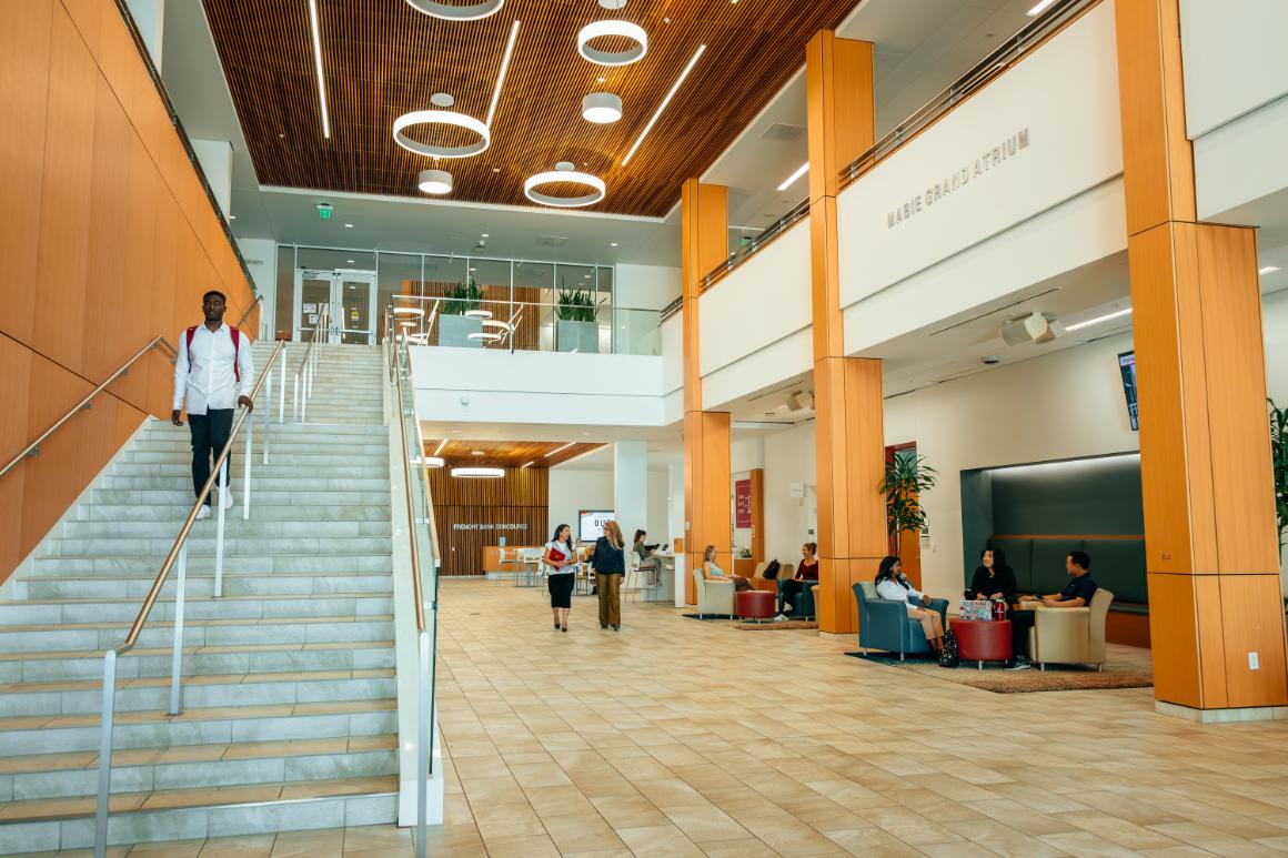 Lobby of Charney Hall with student walking down stairs.