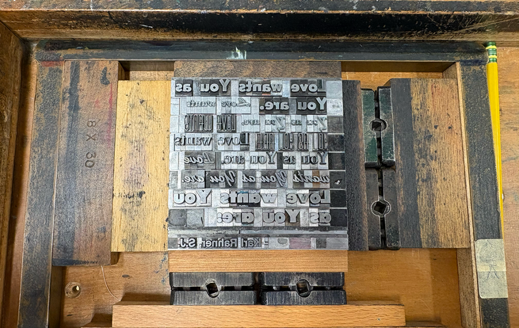 A wooden frame around with reverse letter metal letterpress plates.