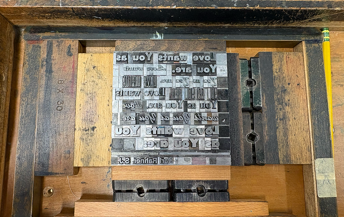 A wooden frame around with reverse letter metal letterpress plates.