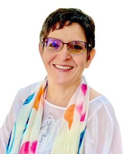 A woman with short black hair wearing glasses and a rainbow colored scarf and white shirt.